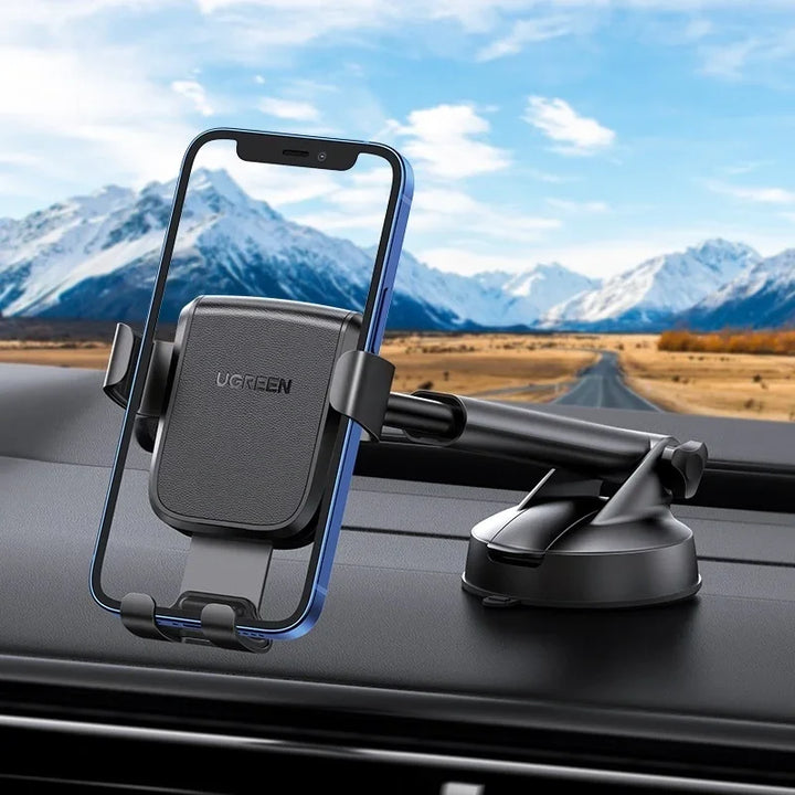 Soporte de celular para auto UGREEN por gravedad con ventosa, compatible con teléfonos, en un coche con vista frontal.