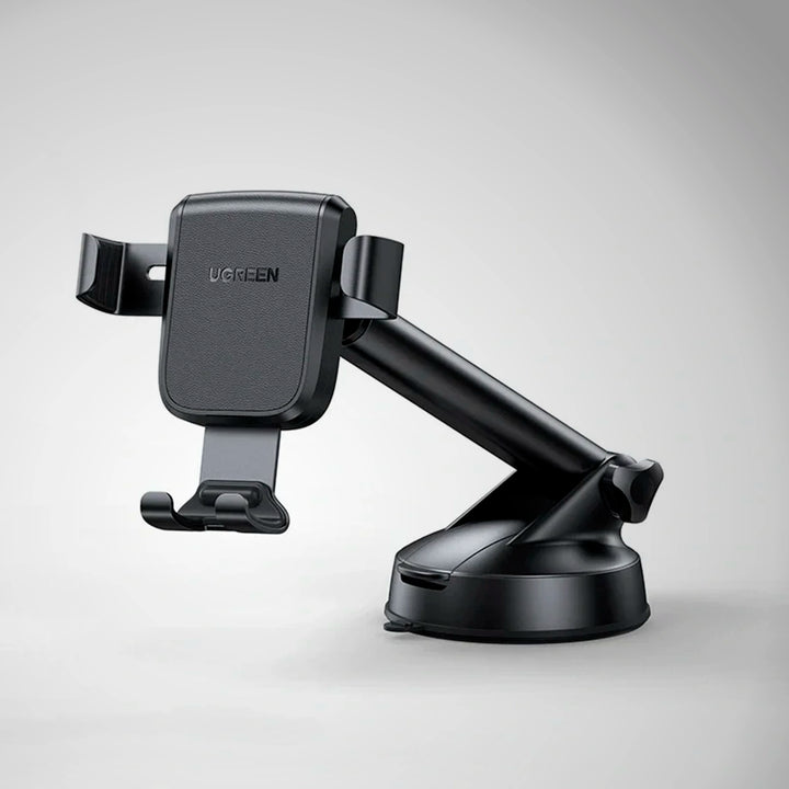 Soporte para celular en auto UGREEN por gravedad con ventosa, compatible con teléfonos, en color negro, sobre tablero de coche.